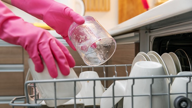 lavavajillas - persona con guantes cargando platos