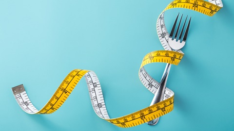 Cinta métrica enrollada a un tenedor
