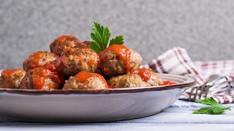 un plato de albóndigas con tomate