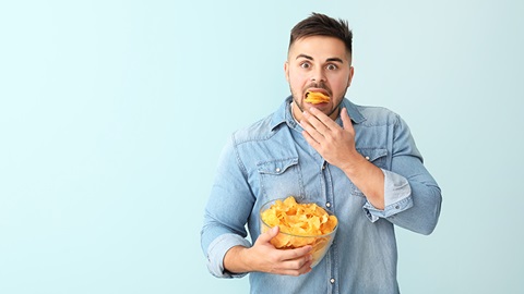 Un chico joven comiendo patatas fritas