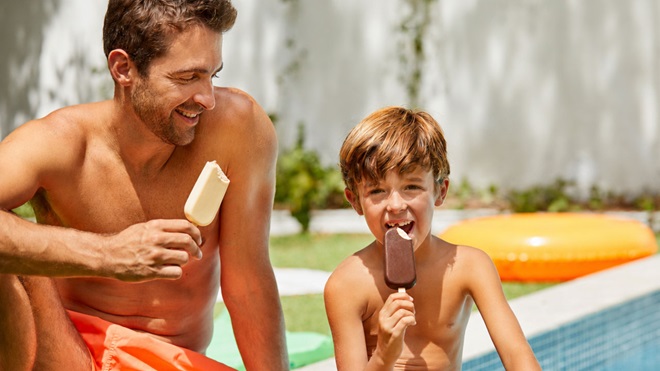 adulto y niño comiendo helados bombón