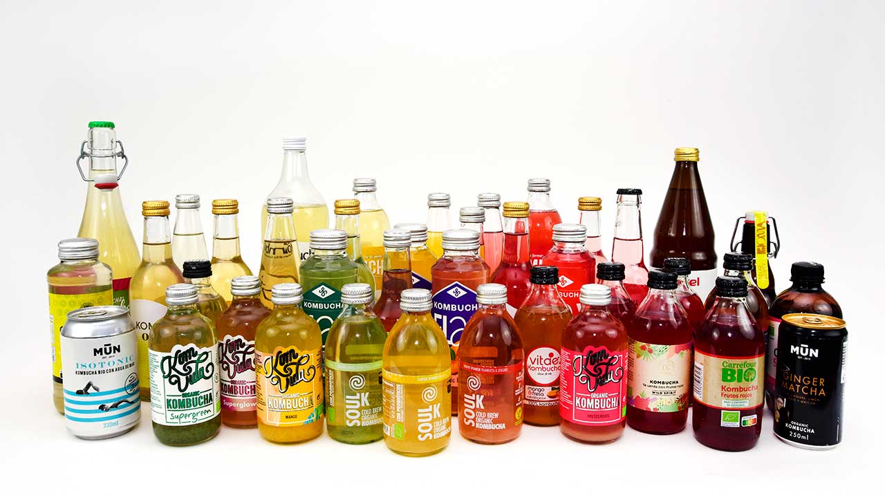 muchas botellas de kombucha de diferentes marcas y colores