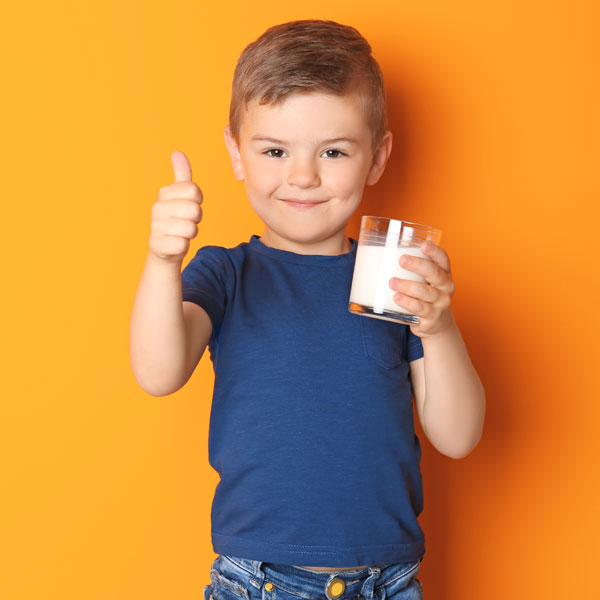 Niño contento con un vaso de leche