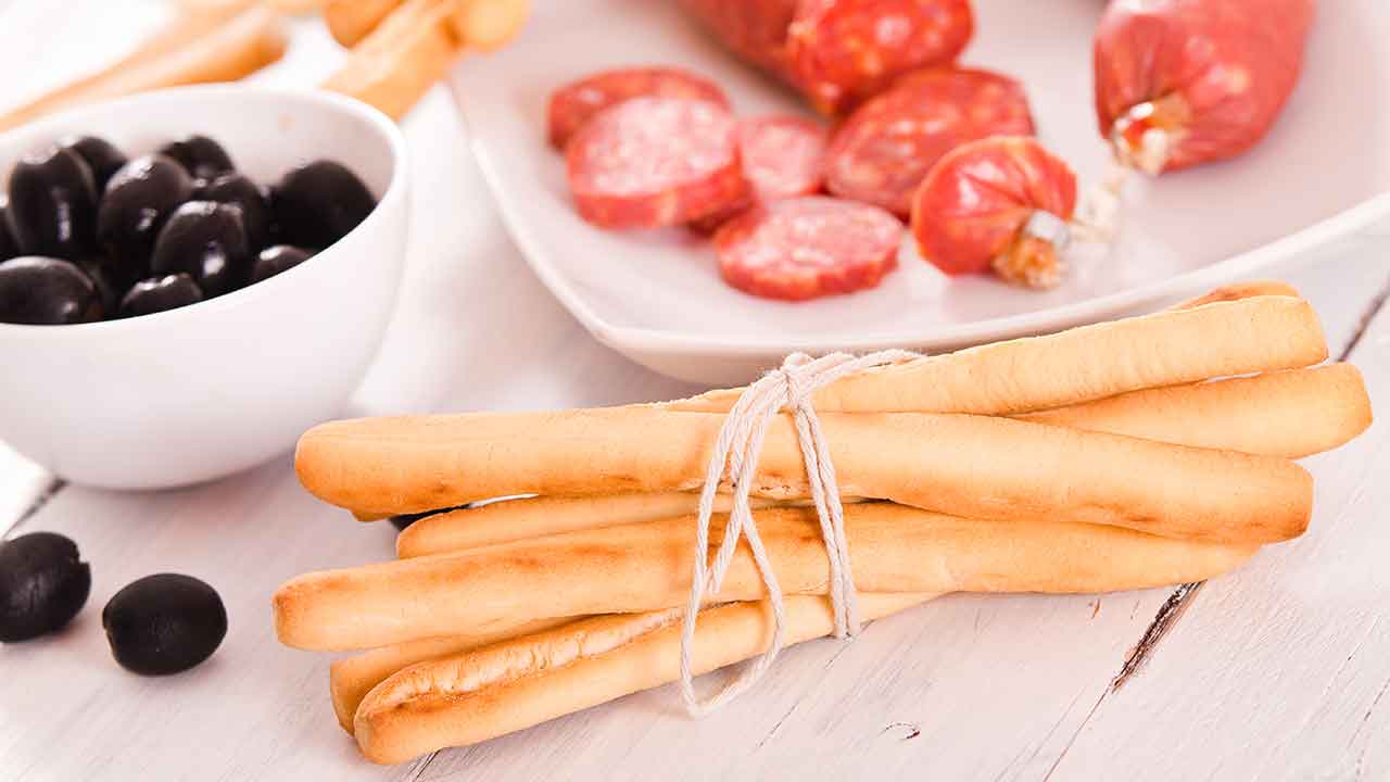 palitos de pan con plato de aperitivos