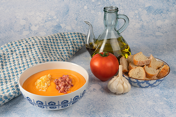 un tazón de salmorejo con los ingredientes de elaboración