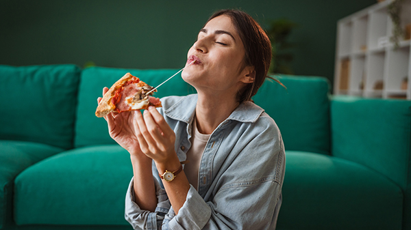 chica comiendo un trozo de pizza