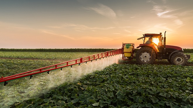 Tractor regando el campo cultivado