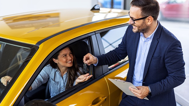 Entregando las llaves de un coche nuevo a una conductora