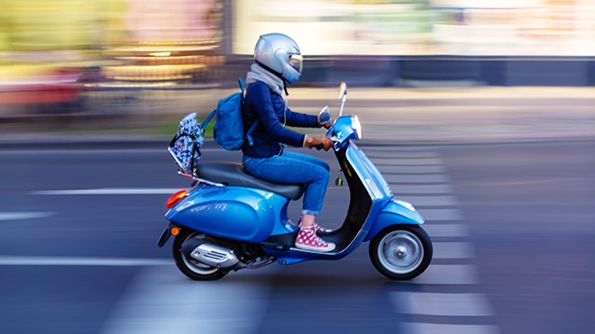 Mujer circulado en una moto tipo scooter