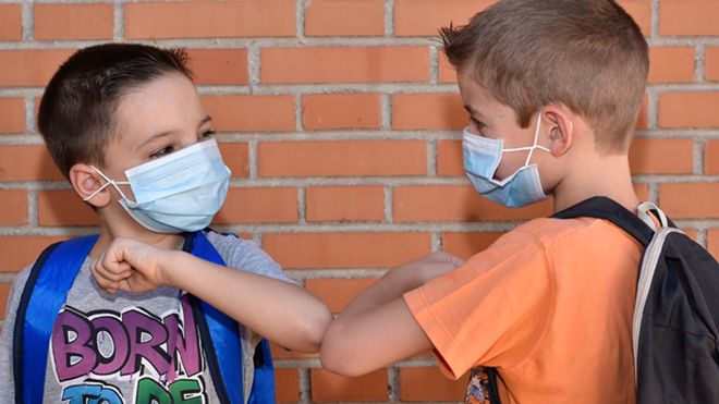 niños con mascarilla y mochila