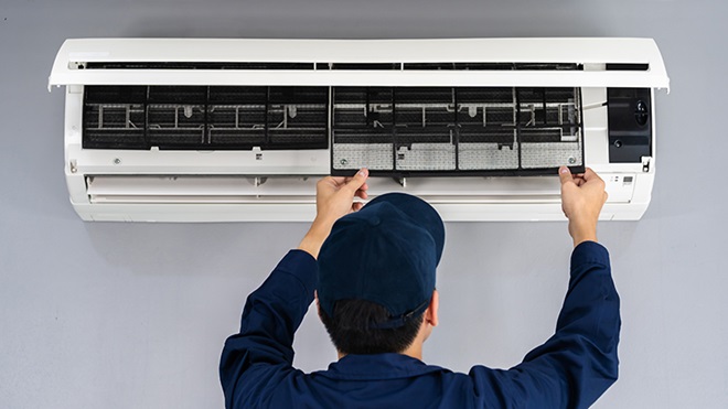 servicios de asistencia técnica - operario revisando aire acondicionado