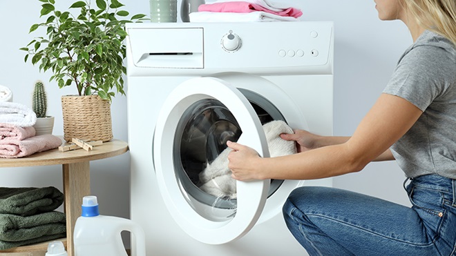 mujer cargando una lavadora