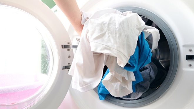 ropa entrando en una lavadora