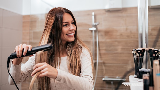 mujer usando plancha de pelo
