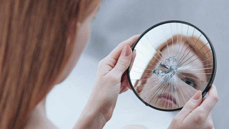 Menor mirándose al espejo y viendo una imagen distorsionada de sí misma