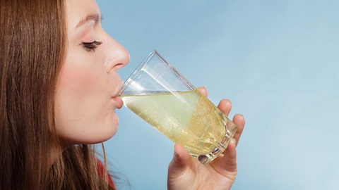 mujer bebiendo vaso suero liquido hidratacion