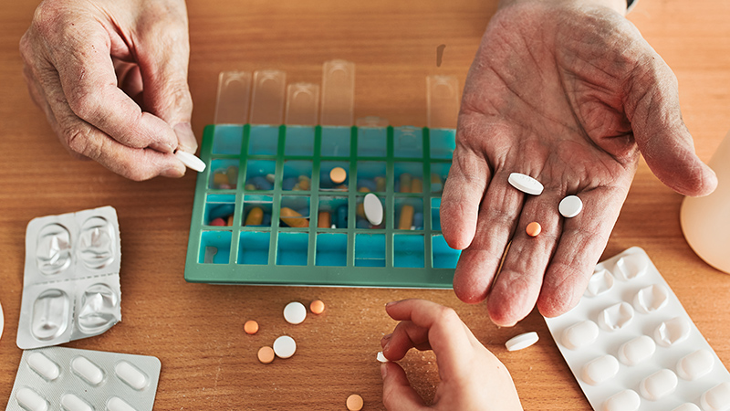 Persona metiendo pastillas en un pastillero