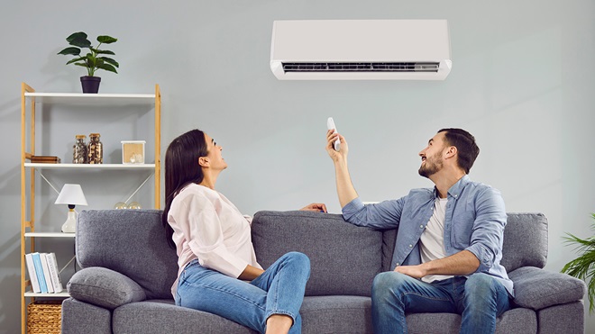 Pareja encendiendo el aire acondicionado
