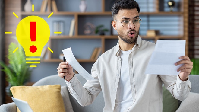 Hombre sorprendido mirando una factura eléctrica