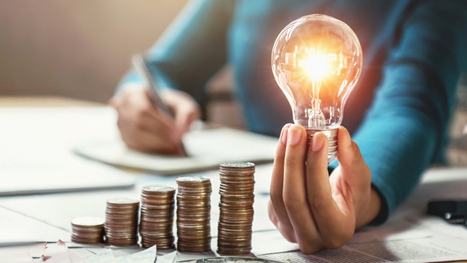 mano-monedas-bombilla-ahorro-energia