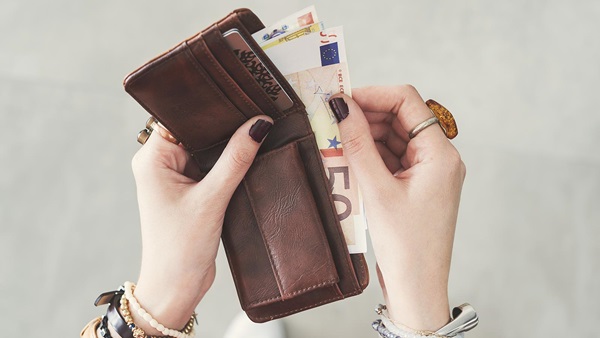 Mujer sacando dinero de su cartera
