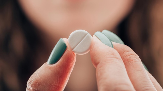 Muchacha sosteniendo pastilla